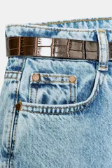 Jeans de tiro alto con diseño wide leg y cinco bolsillos. Presenta cierre frontal con cremallera y botón, e incluye un cinturón a contraste con hebilla metálica.