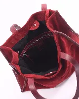 Bolso tipo shopper de gran tamaño, confeccionado en cuero gamuzado color marrón. Presenta estructura rectangular con bordes reforzados en cuero liso oscuro, doble asa de hombro y cierre mediante botón magnético.