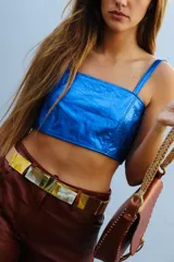 Top corto estilo corset o bandeau, color dorado metálico, con tirantes anchos ajustables.