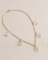 Collar de cadena eslabonada en acero con baño de oro, con múltiples dijes colgantes en forma de gota de cristal facetado tornasolado.