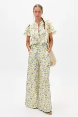 Pantalón de lino con estampado floral en tonos amarillos y azules, de corte palazzo y tiro alto.