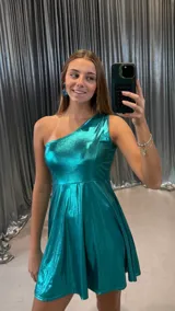 Vestido corto metalizado color turquesa, con escote asimétrico de un solo hombro y falda acampanada.