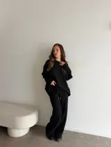 Conjunto de dos piezas color tostado, compuesto por un buzo de cuello redondo con mangas largas y hombros caídos, y un pantalón de corte recto con cintura elástica y cordón ajustable.