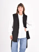 Chaleco largo de color negro con solapas clásicas y bolsillos frontales, diseñado con un corte recto y abierto.