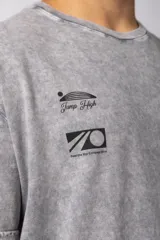 Remera de algodón con efecto lavado ácido en color gris, de corte holgado y manga corta. Presenta estampados gráficos minimalistas en el pecho y cuello redondo acanalado.