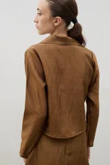 Camisa de manga larga color marrón con textura arrugada, cuello clásico y cierre frontal mediante lazos para anudar.