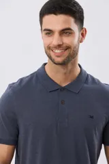 Remera polo de manga corta en color azul melange, con cuello camisero, cierre frontal de dos botones y pequeño bordado en el pecho.