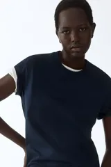 Remera de corte recto en punto suave de algodón, con cuello redondo ribeteado y hombros ligeramente caídos.