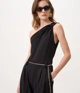 Mono wide leg de crepé color negro, con diseño de un solo hombro y cinturón de cadena metálica integrado.