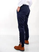 Pantalón de vestir azul marino, de corte recto, con bolsillos laterales y traseros. Se ajusta a la cintura con cinturón de cuero marrón.