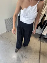 Pantalón palazzo negro con textura floral en relieve.