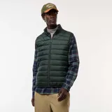 Chaleco tipo puffer de color verde oscuro, con cierre frontal completo, cuello alto y diseño acolchado horizontal.
