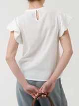Blusa de algodón orgánico y ramie, color blanco, con cuello redondo y mangas cortas adornadas con detalles de crochet.