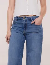 Jean de denim azul de tiro alto, corte wide leg con pierna ancha recta, con cinco bolsillos tradicionales, presillas para cinturón y cierre frontal con botón y cremallera.