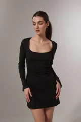 Vestido corto negro de mangas largas con escote cuadrado y frunce lateral.