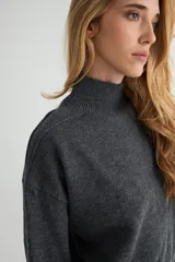 Conjunto de dos piezas compuesto por un sweater de cuello alto con aberturas laterales en el ruedo y un pantalón de corte recto y holgado, ambos confeccionados en tejido de punto suave.
