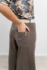 Pantalón de corte wide leg color marrón, con tiro medio, costuras a contratono y cierre frontal con botón metálico.