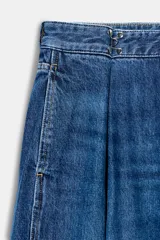 Jeans de tiro alto con corte loose fit y pernera holgada. Presenta detalle de corchetes en la cintura, bolsillos frontales y bolsillos de plastrón en la parte trasera. Cierre frontal con cremallera y botón.