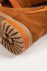 Bota tipo chelsea de caña media en color beige, con suela track dentada y paneles laterales elásticos acanalados.