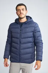 Campera puffer de hombre con capucha, cierre frontal completo y bolsillos laterales. Diseño acolchado con costuras horizontales.