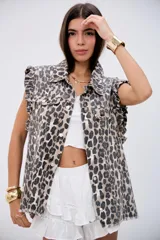Chaleco de denim con estampado animal print, cuello camisero, cierre frontal con botones metálicos y volados en las sisas.