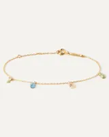 Pulsera dorada con cadena fina y cuatro dijes colgantes de circonitas multicolores en forma de gota.
