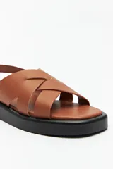 Sandalias color beige con capellada entrelazada y agarre ajustable en el talón. Plataforma de 3cm de alto y suela negra.