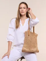 Cartera tipo shopper con estructura externa de tejido tipo red en color tostado, base sólida reforzada y correas dobles integradas de cuero sintético. Cuenta con compartimento principal interior con cierre.