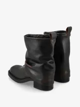 Bota de cuero color negro, de caña media con diseño arrugado y taco bajo.