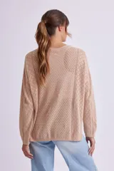 Buzo de punto fantasía color beige con diseño calado, escote redondo y mangas largas.