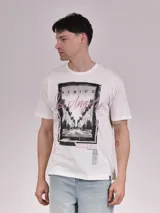 Remera manga corta color crudo con estampa rectangular con foto de calle con palmeras y texto en color fucsia.