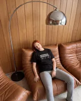 Remera negra de corte regular con estampa gráfica en la espalda que combina tipografía clásica y texturizada con la frase Cultura de Barrio.