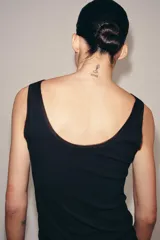 Camiseta de tirantes anchos confeccionada en algodón con textura acanalada. Presenta escote redondo con detalle de aplicación de tejido tipo tul a tono y bajo recto.