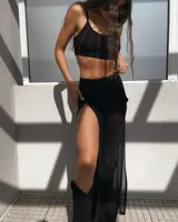 Conjunto de dos piezas compuesto por un top corto tipo deportivo de escote redondo y una falda larga de tiro alto con una abertura lateral pronunciada, confeccionado en tela semitransparente.