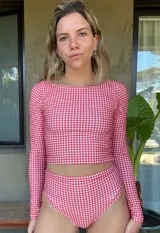 Top de lycra con estampado a cuadros rojos y blancos, de manga larga y corte ajustado.