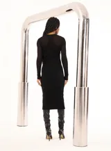 Vestido midi negro de tejido de punto acanalado, con cuello redondo y mangas largas. Presenta un panel de tejido calado en la parte superior del pecho.