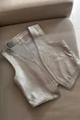 Chaleco clásico plateado de cuero ovino, con cuello en V y sin cierre.