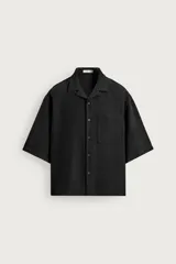 Camisa negra boxy fit de manga corta y cuello bowling, con bolsillo aplicado en el pecho y cierre frontal de botones.