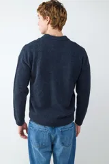 Suéter de punto suave color azul marino, con cuello polo y cierre frontal de tres botones.