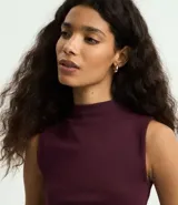 Musculosa básica de cuello alto, sin mangas, confeccionada en una mezcla de algodón, modal y elastano. Presenta un diseño ajustado y minimalista, ideal para uso diario.