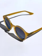 Lentes de sol Osten modelo Niza con armazón redondo de acabado mate en color mostaza y cristales oscuros polarizados con protección UV 400.