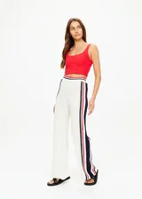 Pantalón de punto abierto de algodón orgánico color crema con rayas verticales en rojo, azul marino y verde pino. Cintura elástica acanalada con rayas de punto y silueta de pierna ancha.