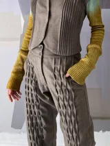 Pantalón babucha de lana color gris con textura en las piernas y elástico con broches en los tobillos.