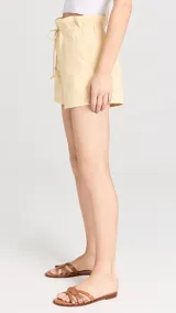 Short amarillo de tiro alto con gran volumen, elástico en la parte trasera y cordón de ajuste en la cintura.