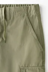Pantalón cargo de corte relajado confeccionado en lona de algodón. Presenta bolsillos laterales con solapa, bolsillos al bies y bolsillos traseros. Incluye pliegues reforzados en las rodillas y cierre con botón.