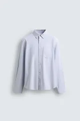 Camisa de corte regular fit confeccionada en tejido de algodón con diseño de rayas finas. Presenta cuello abotonado, manga larga con puños abotonados, bolsillo plastrón en el pecho y cierre frontal con botonadura.