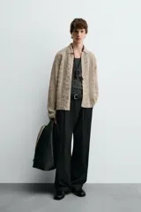 Sobrecamisa de hombre color beige, confeccionada en tejido de crochet con estructura abierta, cuello solapa, manga larga y cierre frontal de botones.