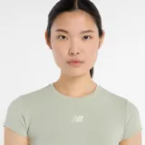 Remera deportiva New Balance de corte crop, con mangas cortas y cuello redondo. Presenta un diseño ajustado con logo de la marca estampado en el centro del pecho y paneles laterales en contraste.