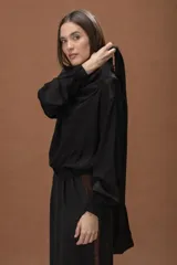 Blusa de satén color negro, con cuello drapeado, mangas largas con puños elásticos y ruedo con elástico en la cintura.