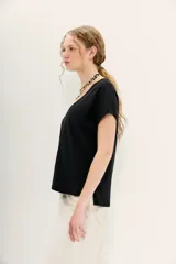 Remera negra de manga corta con escote en V y calce holgado.